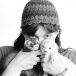 a woman holding two ferrets